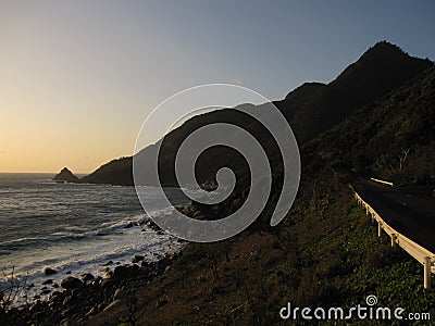 Road, mountains and the sea during sunset Stock Photo